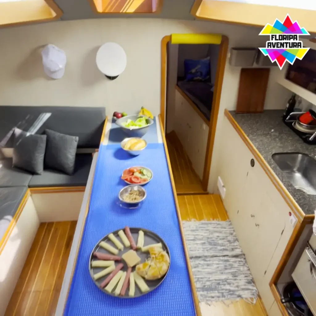 Table set inside the sailboat with charcuterie board, fruits, and snacks for passengers.