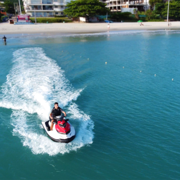 Instrutor explicando uso do jetski com colete e equipamento de segurança antes do passeio em Florianópolis.