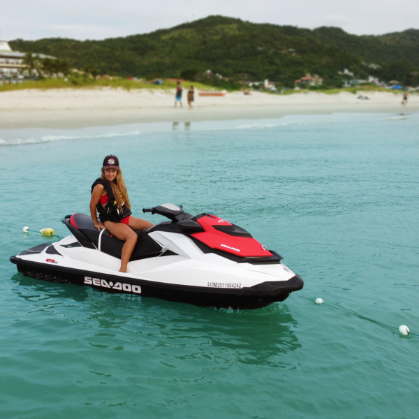 Casal pilotando jetski em Florianópolis durante passeio curto com vista da costa norte da ilha.
