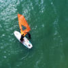 Equipamentos de windsurf como prancha, vela e roupa de borracha disponíveis nas aulas em Florianópolis.