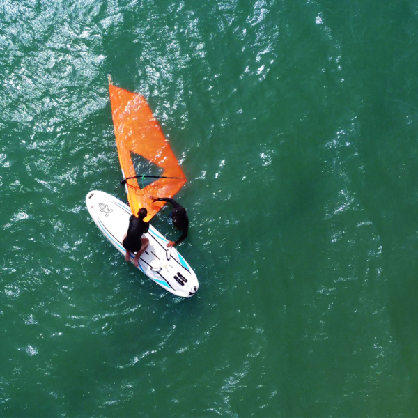 Equipamentos de windsurf como prancha, vela e roupa de borracha disponíveis nas aulas em Florianópolis.