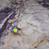 Equipamentos de escalada e instrutor auxiliando participantes durante atividade segura em Florianópolis.